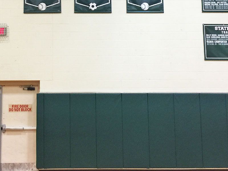 plain green wall pads in high school gym